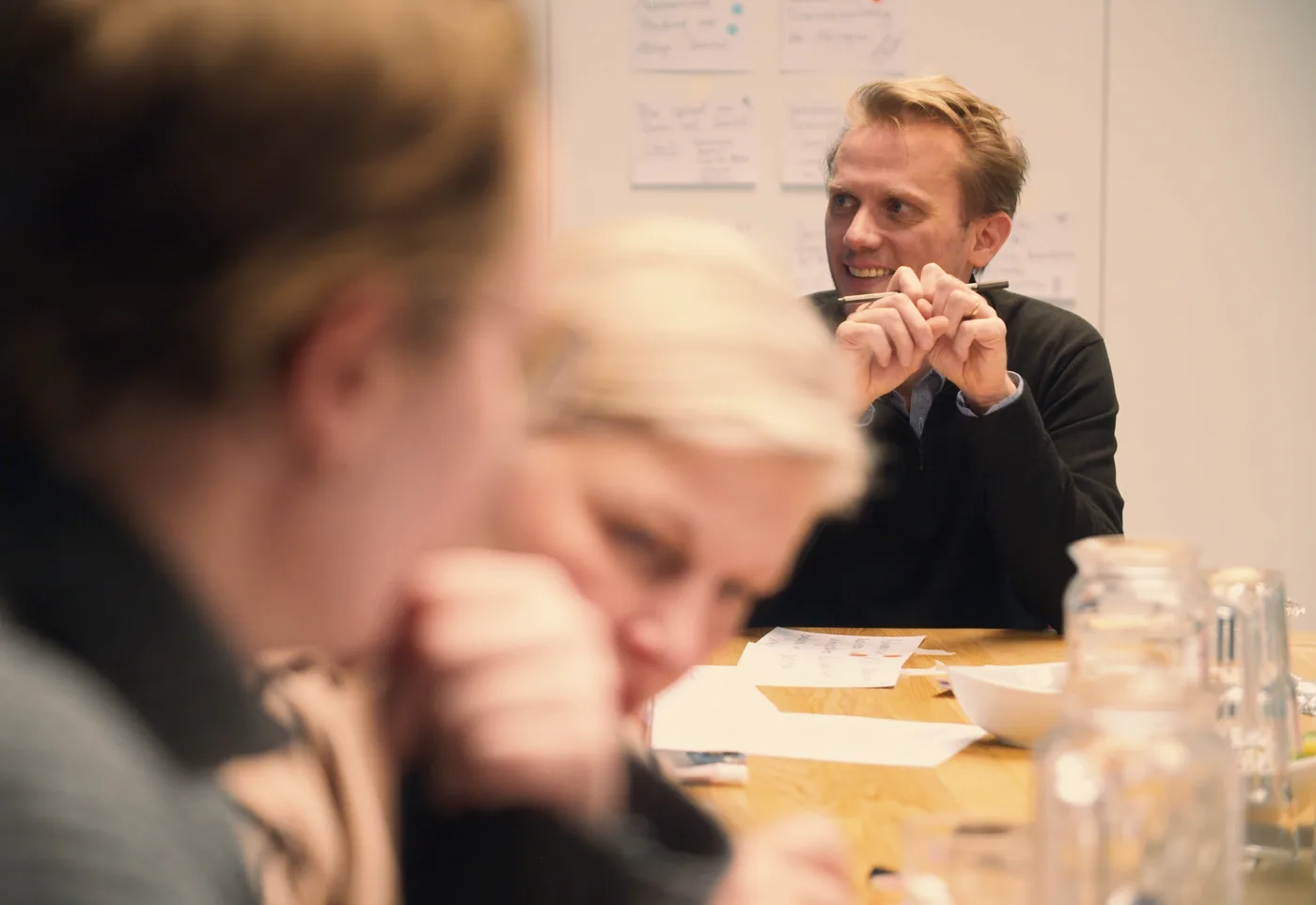 Marc Weimer-Hablitzel in einer Workshop-Situation, lächelnd und sitzend am Tisch